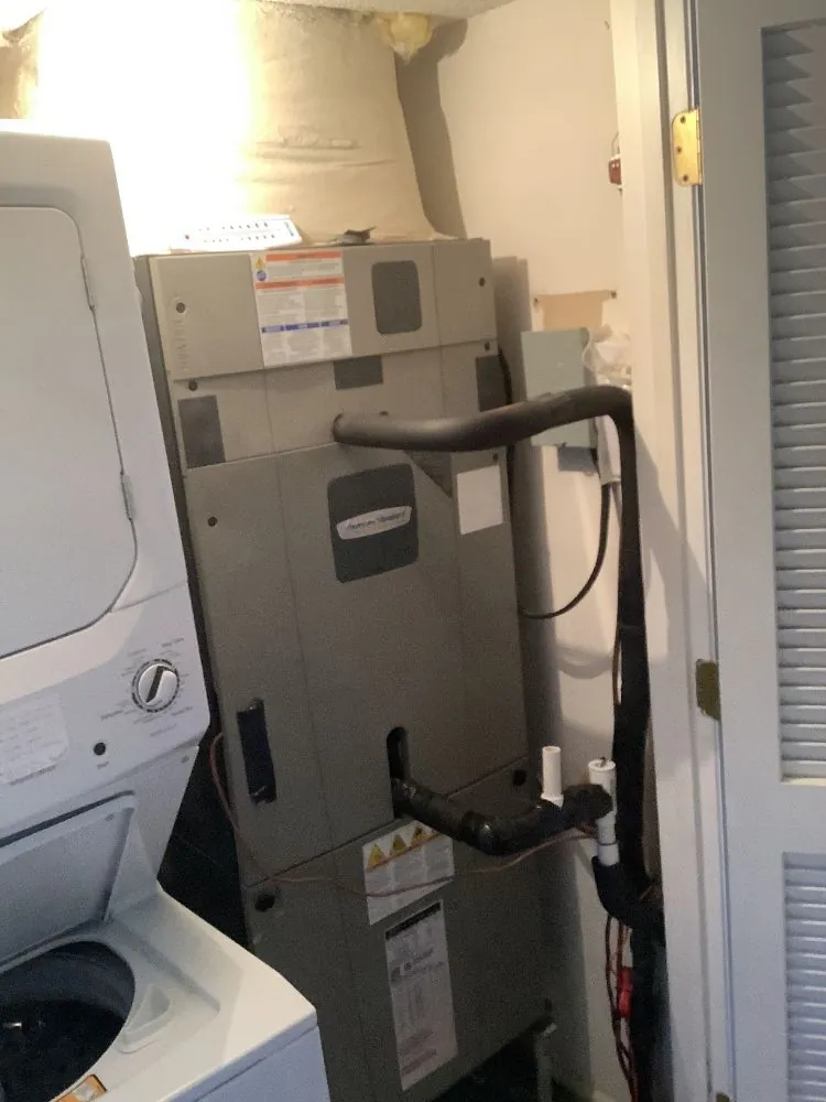 Indoor HVAC unit in a utility closet beside a washer